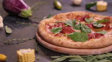 Close-up delicious fresh pizza on a wooden plate. Slider shot.