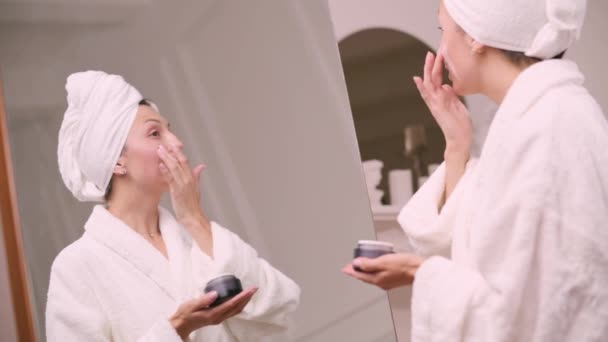 Young Attractive Woman Bathrobe Applies Cream Her Face Bathroom Female — Video