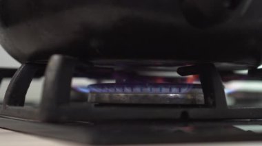 Close-up burning gas stove fire. The pan is heated on the stove.