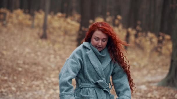 Νεαρή Κοκκινομάλλα Γυναίκα Παγώνει Στο Φθινοπωρινό Πάρκο Γυναίκα Προσπαθεί Κρατήσει — Αρχείο Βίντεο