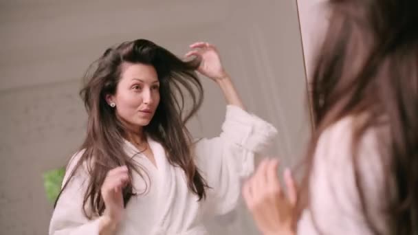 Young Attractive Woman Bathrobe Examines Her Hair Mirror — Videoclip de stoc