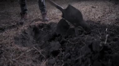 Katil gece mezar kazıyor. Genç korkutucu adam sahada çukur kazıyor. Cadılar Bayramı konsepti.