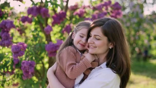 Young Mother Holds Cute Little Daughter Her Arms Flowering Tree — Stock Video