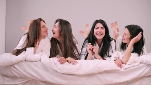 Girlfriends Having Fun Four Young Females Bathrobes Lie Bed Have — Αρχείο Βίντεο