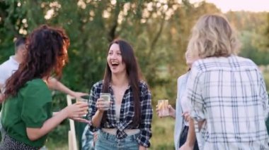 Genç kadınlar açık havada dans eder. Bir grup neşeli kız arkadaş birlikte vakit geçirir..