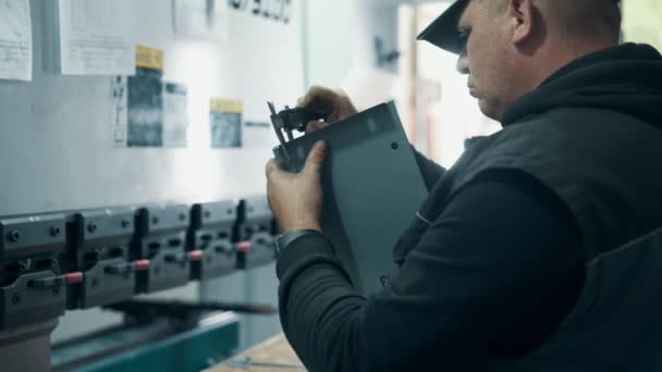 工場内のキャリパーで部品を測定する技術者 — ストック動画