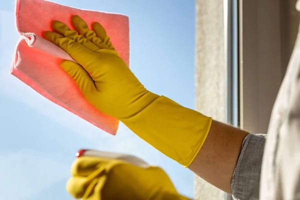 man washing windows at home, office shirt with rolled up sleeves, pink cloth, yellow rubber gloves, House cleaning concept