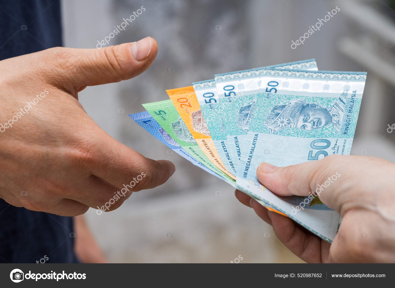 一份马来西亚钱的档案林吉特从头到脚交给另一个人——图库图片© rochu_2008 #520987652