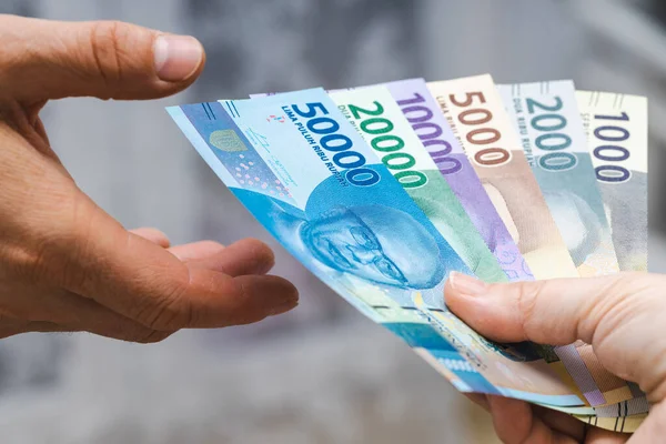 Indonezyjskie Rupii Akta Banknotów Przekazane Innej Osobie Ręki — Zdjęcie stockowe