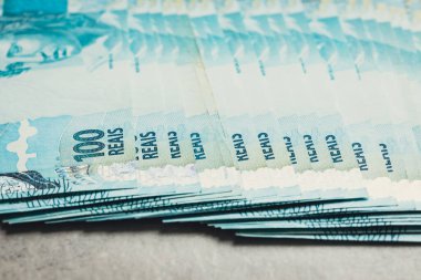 Büyük miktarda Brezilya parası, 100 reais banknot, gri arka plan 