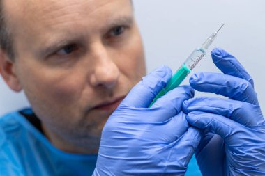 Elinde şırınga tutan bir doktor.