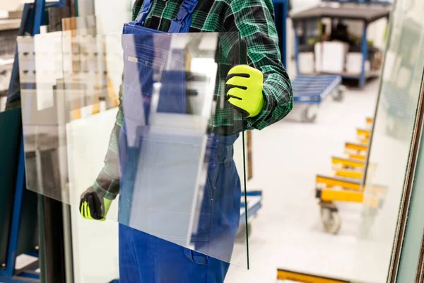 Camcı elinde cam bir bölme taşıyor, Cam Fabrikası. 