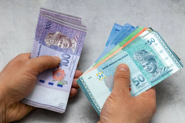 Monnaie Malaisienne Tenue Dans Les Deux Mains Beaucoup Ringgit Fond — Photo