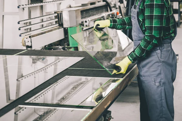 The glazier removes the cut glass from the specialized table in the glass factory, Cutting glass panels