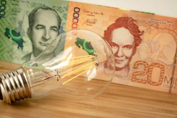 Costa Rican money and light bulb, Concept of rising energy and electricity prices in Costa Rica