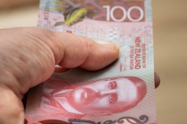 Yeni Zelanda 100 dolarlık banknotu olan bir kadın.