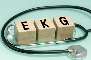 EKG ekokardiyogram, kalp atış hızı testi, tıbbi konsept, tahta bloklar ve stetoskop yazıtları.,