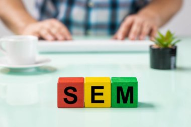 Bilgisayarda ofis çalışanı, tahta bloklar, SEM kısaltması, Arama Motoru Pazarlama,