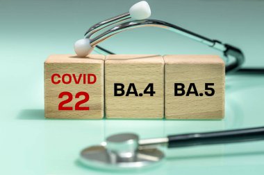 note on wooden blocks Covid 22 and NA.4 and BA.5. Scientific symbols of the coronavirus evolved from the omicron. The concept of the spread of new mutations of the virus in 2022