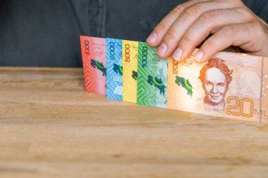 Costa Rica currency colon, Man holds money in his hand, All denominations, Business and financial concept