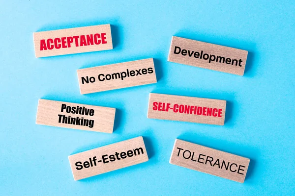 positive thinking, personal acceptance, Personality development, self-esteem boosting motivational slogans written on wooden blocks, Blue background