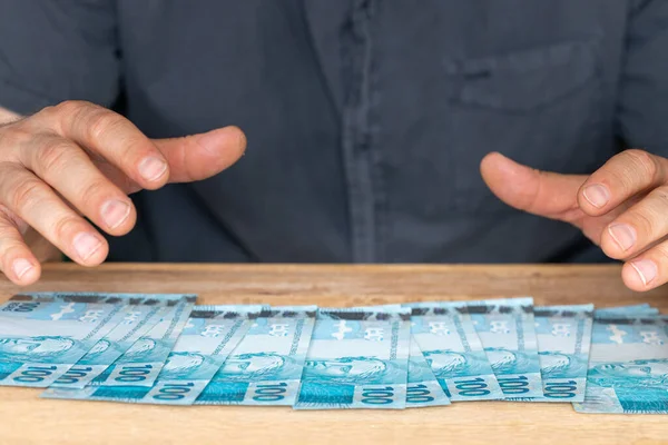 Man Reaching Money Spread Desk Large Amount Brazilian Finances Banknotes — Foto de Stock