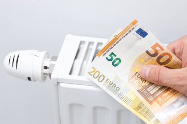 Home heating prices, Increase in energy prices in the European Union, Heater and euro banknotes in your hand