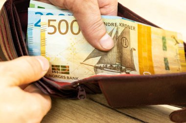 Norveç cüzdanlarının içeriği, enflasyon sırasında ev ekonomisi kavramı, adam açık bir cüzdan gösteriyor.