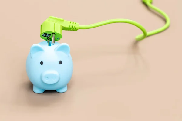 Piggy bank and green electric cable, Environmental concept promoting natural and economical sources of energy, Modern technologies of obtaining green energy, place for an inscription