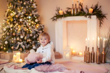 Sevimli çocuk, yeni yılda kendisine hediye edilen en sevdiği oyuncağına sarılıyor.