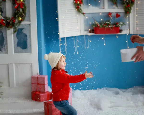 Dziewczyna w czerwonym swetrze na tle dekoracji nowego roku i śniegu — Zdjęcie stockowe