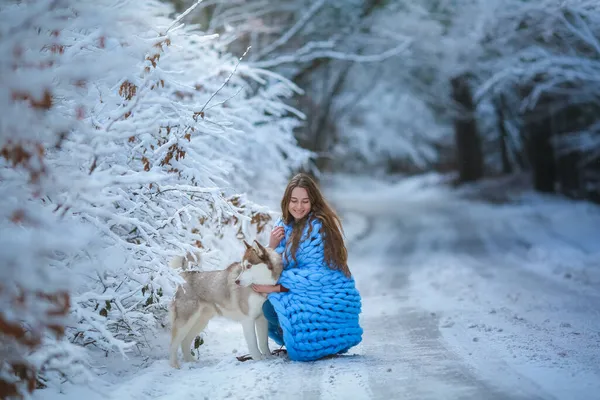 Μια γυναίκα με ένα καθαρόαιμο σκυλί σε ένα χιονισμένο δασικό δρόμο — Φωτογραφία Αρχείου