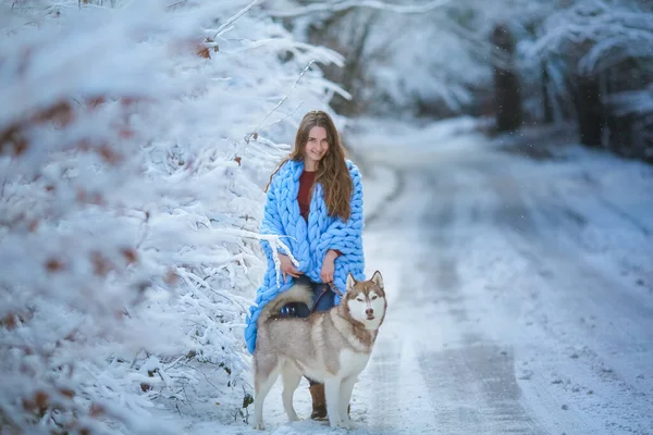 Γυναίκα χειμώνα αξίζει στο δάσος και κρατά το σκυλί με σφιχτό λουρί — Φωτογραφία Αρχείου