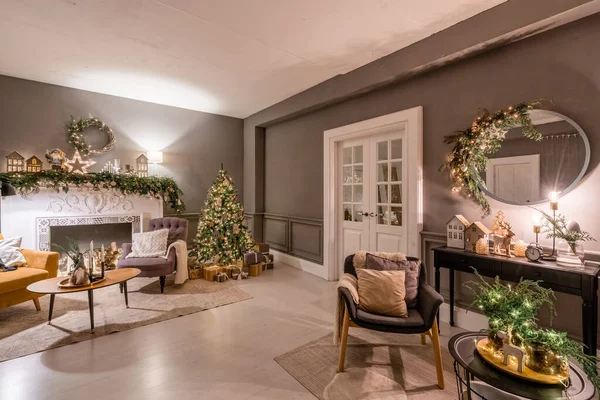 Apartamentos clásicos con árbol de Navidad decorado y regalos. Noche de Navidad a la luz de velas y guirnaldas. Vivir con chimenea y estuco. — Foto de Stock