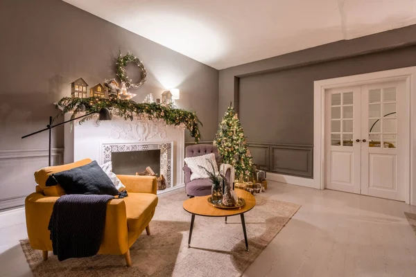 Appartamenti classici con albero di Natale decorato e regali. Serata di Natale alla luce di candele e ghirlande. Soggiorno con camino e stucco. — Foto Stock