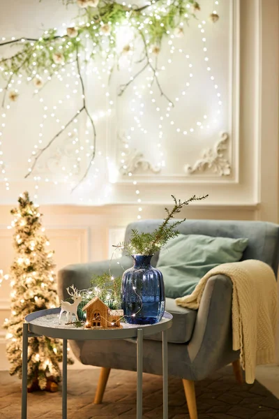 Egy karosszék párnákkal egy hangulatos szobában Klasszikus apartmanok díszített karácsonyfával és ajándékokkal. Karácsony este a gyertyák és koszorúk fényében. — Stock Fotó