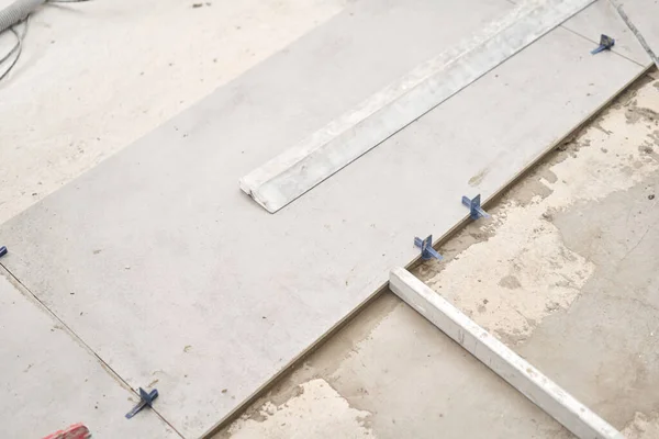 Grandes baldosas de cerámica en el estilo loft, de hormigón. Reparación del comedor en la casa, lugar para la cocina, cambio de pavimento. Interior vacío para el diseño, pared de hormigón gris. — Foto de Stock