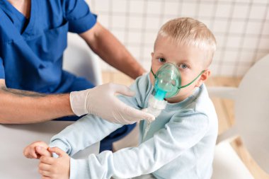 Bir çocuk doktoru akciğer hastalığını teşhis eder ve tedavi sağlar. İlacı nebulizör spreyiyle solu. Doktoru ziyaret eden sevimli küçük çocuğun portresi..