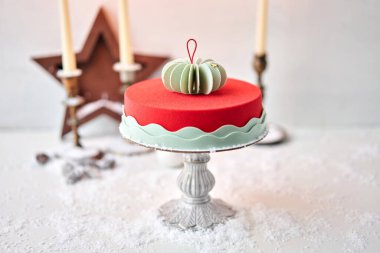 Kırmızı kadifeyle kaplı kremalı pasta. Karla kaplı bir masada tatlı. Modern Avrupa pastası. Fransız mutfağı. Noel teması. Boşluğu kopyala