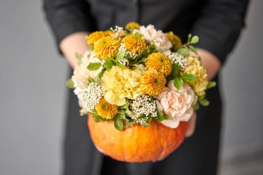 Beyaz masadaki balkabağında çiçek aranjmanı. Dekorasyon için taze kesilmiş çiçekler. Avrupa çiçekçisi. Taze kesilmiş çiçek getirdim..