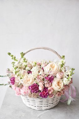 Wicker sepetinde çiçek aranjmanı. Kadın elinde güzel bir buket karışık çiçek. Güzel, taze bir buket. Küçük çiçekçi ve çiçek teslimatı..