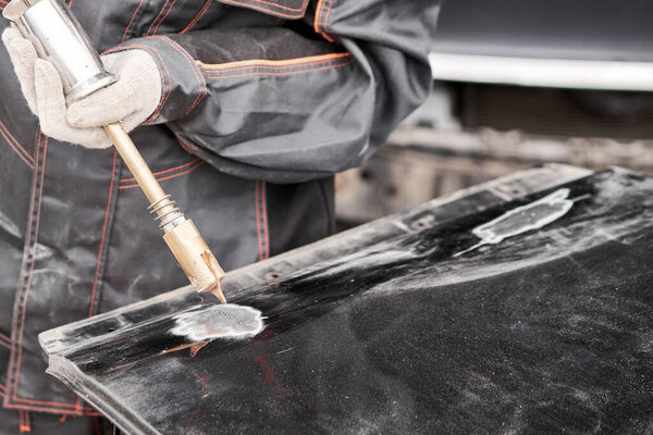 Наблюдатель, сварочный аппарат для выравнивания вмятин на кузове автомобиля. точечная сварка металла. Ремонтник починил поврежденный автомобиль.