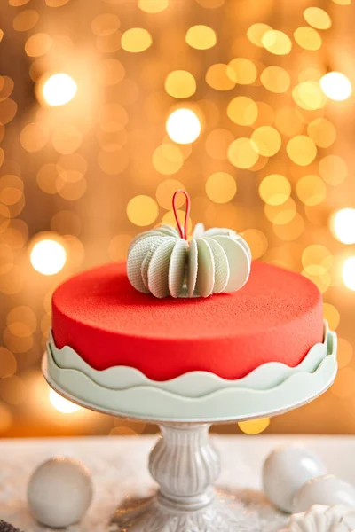 Mousse dort pokrytý červeným velurem. Ozdobné lampy na pozadí. Moderní evropský dort. Francouzská kuchyně. Vánoční téma. Kopírovat prostor — Stock fotografie