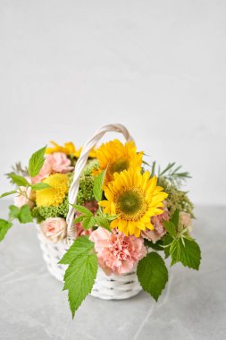 Wicker sepetinde çiçek aranjmanı. Güzel bir buket karışık çiçek. Güzel, taze bir buket. Küçük çiçekçi ve çiçek teslimatı..