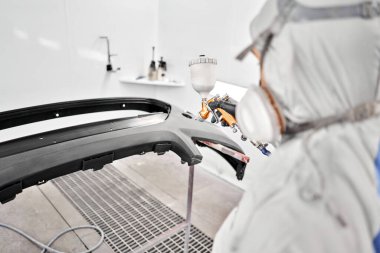 Boya tabancası profesyoneller tarafından profesyonel bir boya işi için tasarlanmıştır. İşçi, arabanın parçalarını özel boya odasına boyuyor, kostüm ve koruyucu giysiler giyiyor. Araba servis istasyonu..