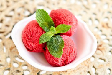 İtalyan gelateria 'sı. Naneli dut dondurması. Eski bir masada beyaz bir kasede üç top. şerbet