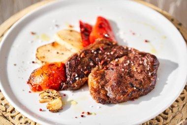 Beyaz tabakta kaburga bifteği. Garnitürlü sebze. Barbekü restoran menüsü.