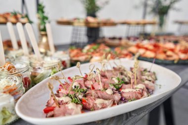 Kurutulmuş domatesli domuz jambonlu nefis kanepeler. Lezzetli büfe masası. Yaz partisi. Yemek konsepti