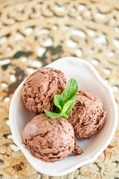 Cokelat es krim dengan daun mint. tiga bola dalam mangkuk putih di meja vintage. — Stok Foto