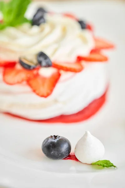 Pavlova is a meringue-based dessert with a crisp crust topped. Decorated strawberry, mint leaf, blueberry and whipped cream. Restaurant sweet food — Stock Photo, Image